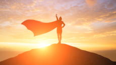 woman wearing a cape on a mountain, representing adoptive parents' "adoption heroes," including their child's birth mother or their social worker