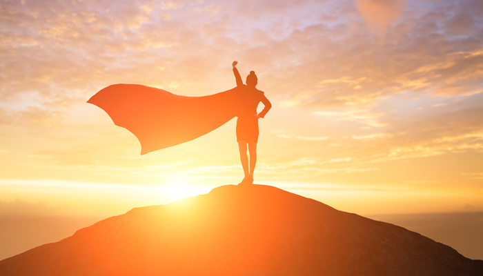 woman wearing a cape on a mountain, representing adoptive parents' "adoption heroes," including their child's birth mother or their social worker