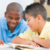 A transracially adopted boy joking with a friend in class