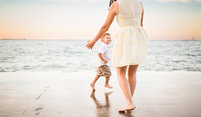 A mother plays with her son through foster adoption on the beach and shares the adoption story behind the photo