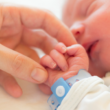 parent holding newborn baby's hand in the hospital after a "stork drop" last-minute adoption placement