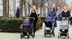 Three mothers pushing strollers in the city, one asking a nosy adoption question