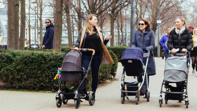 Three mothers pushing strollers in the city, one asking a nosy adoption question
