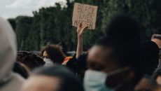 Anti-racist individuals at a Black Lives Matter protest, showing support through actions, not just words