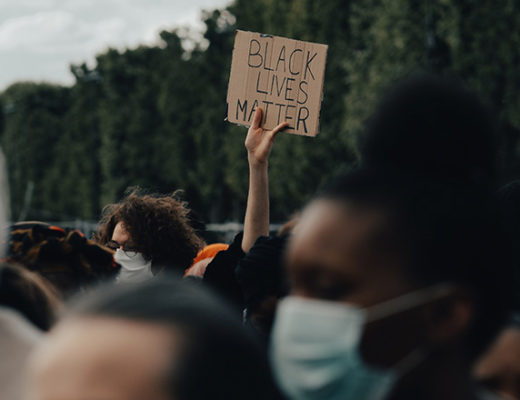 Anti-racist individuals at a Black Lives Matter protest, showing support through actions, not just words