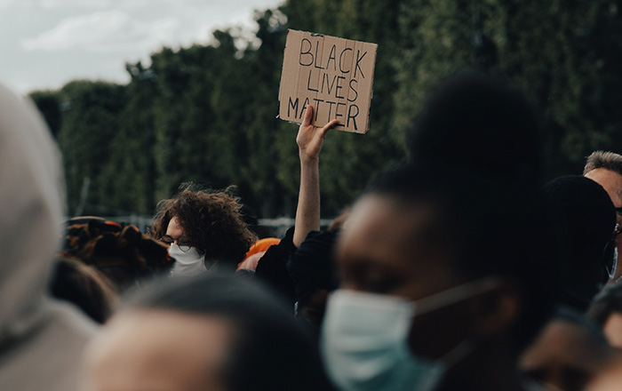 Anti-racist individuals at a Black Lives Matter protest, showing support through actions, not just words